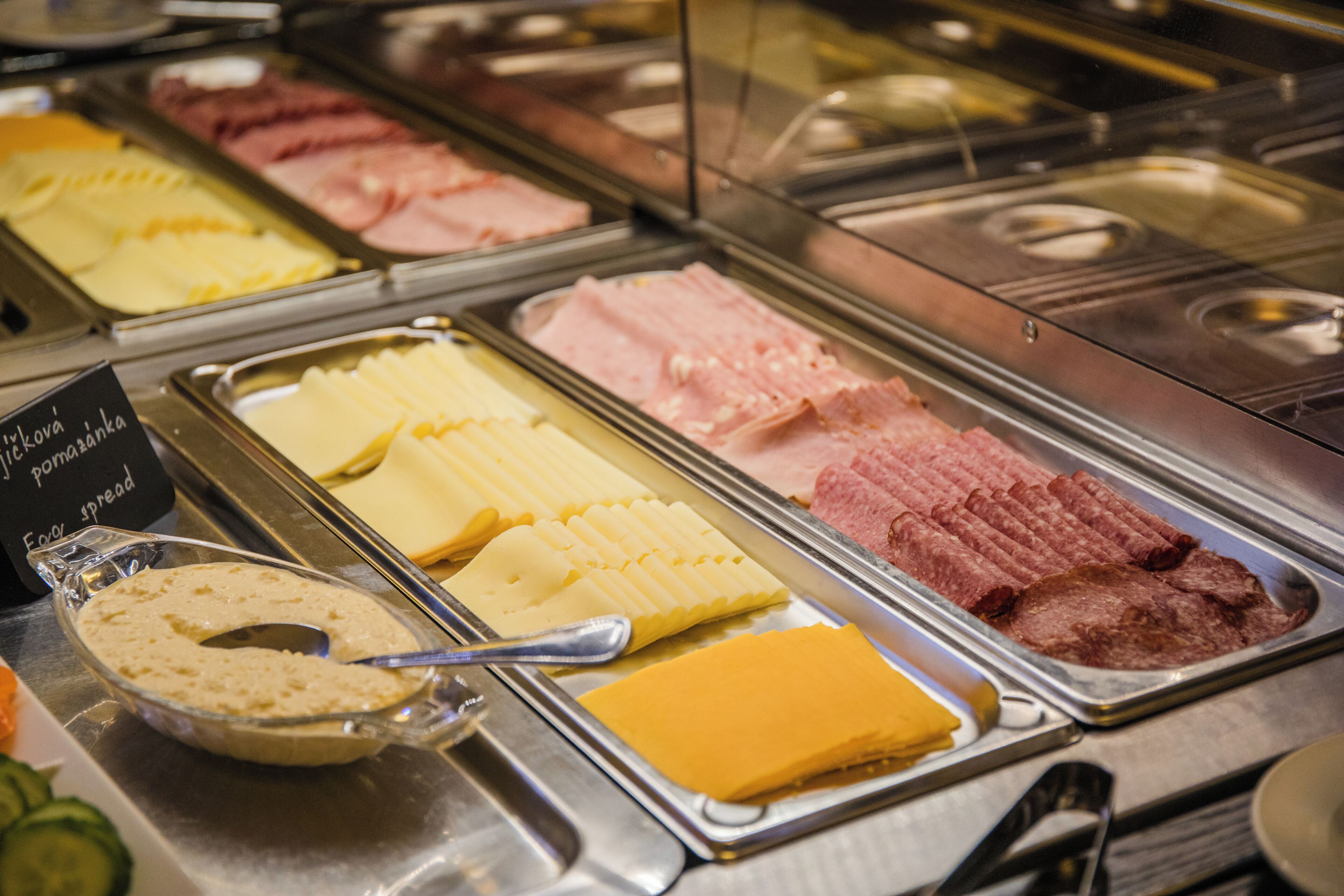 Un buffet proposant une variété de plats, notamment des viandes, des fromages et des tartinades.