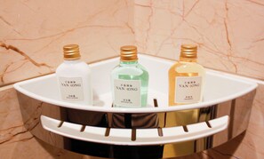 Three bottles of Van Long body lotion, shower gel, and shampoo on a white marble sink. - VANHONG Hotel (Guangzhou)