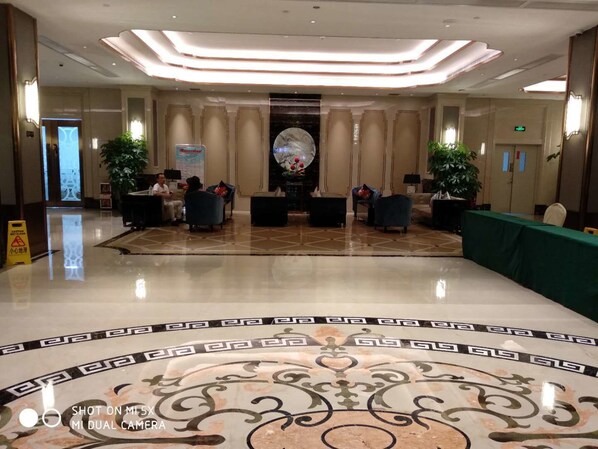 A spacious lobby with a polished marble floor, a reception desk, and seating areas. - VANHONG Hotel (Guangzhou)