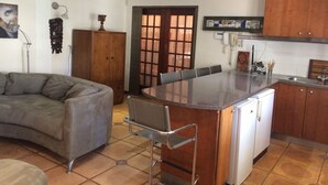 Une cuisine avec un îlot central, une table à manger et un canapé.