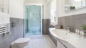 Une salle de bain moderne avec une douche à parois de verre, un lavabo blanc et des toilettes.