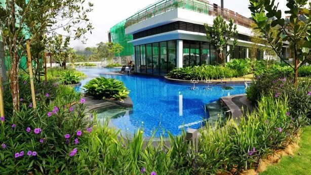 A modern building with a swimming pool surrounded by lush greenery and purple flowers. - Midhill by Cheng (Genting Highlands)