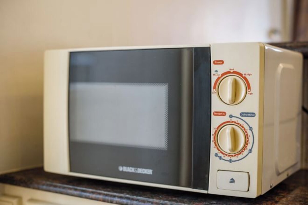 A microwave with a digital display and two control knobs.