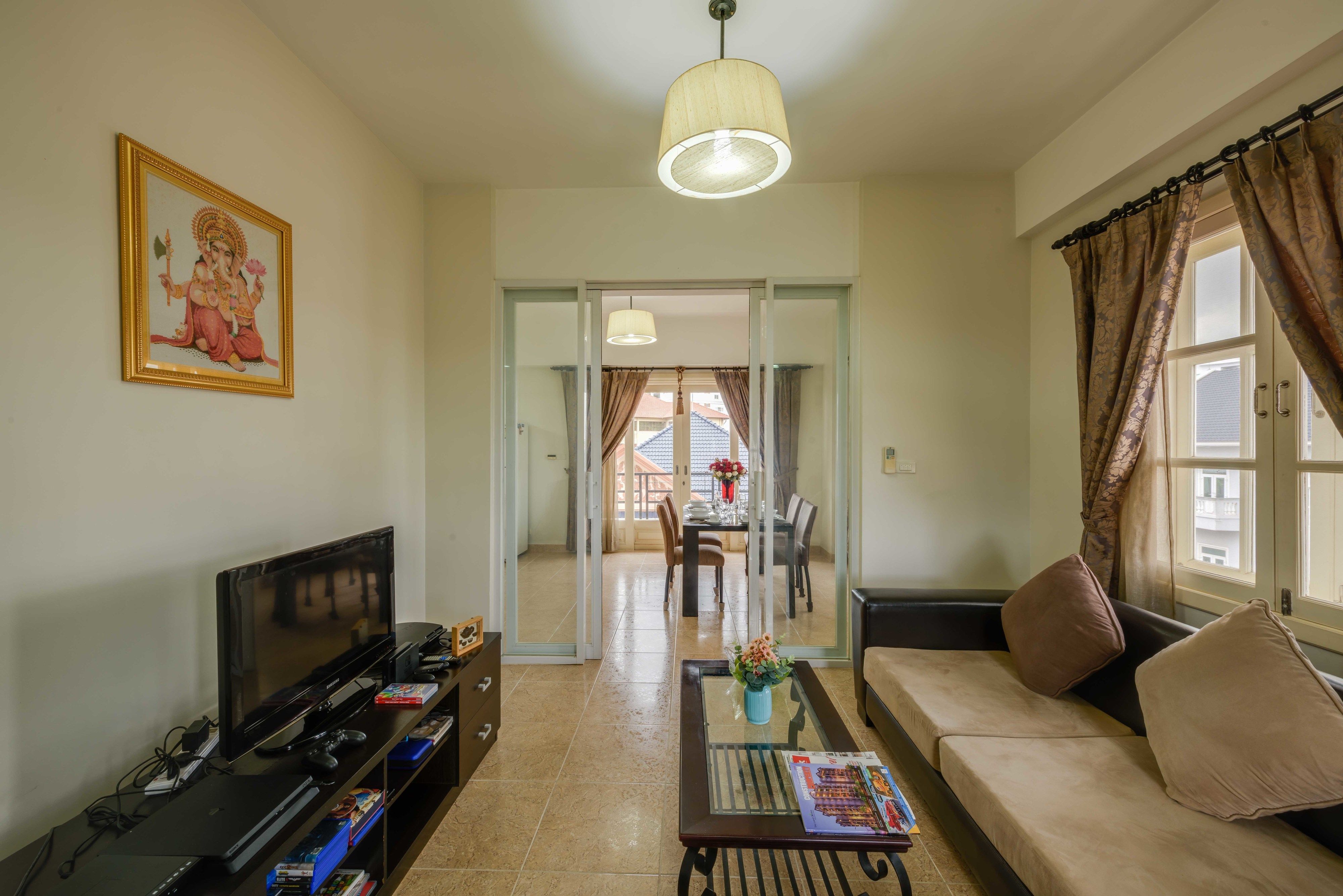 Una sala de estar con sofá, televisor y un cuadro en la pared.