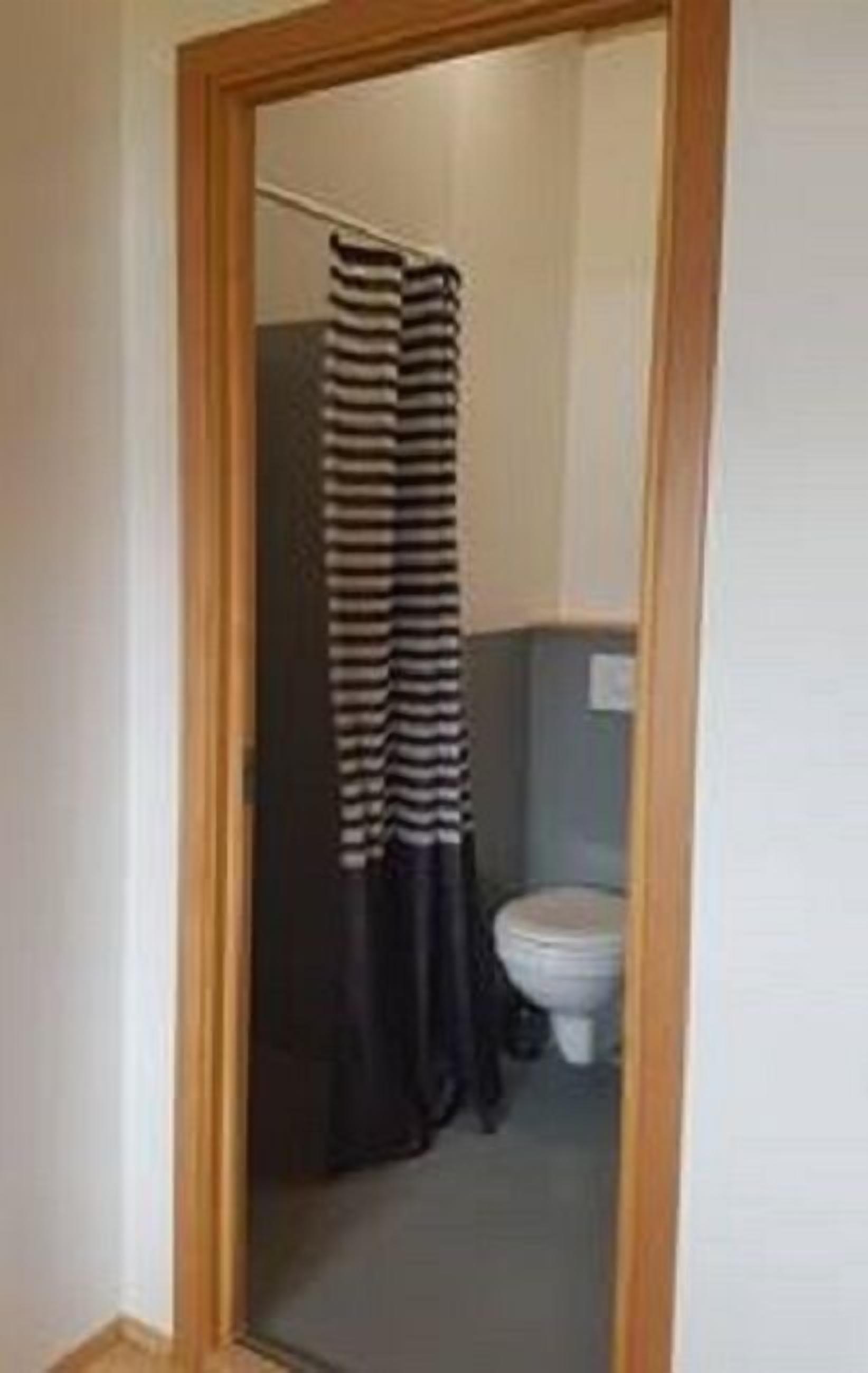 A bathroom with a toilet and a shower curtain.