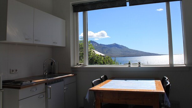 A kitchen with a view of a lake and mountains. - Lindarbrekka (Djupivogur)