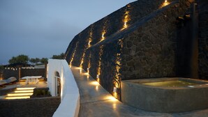 Un bâtiment en pierre doté d’une piscine et d’un espace extérieur aménagé pour s’asseoir.
