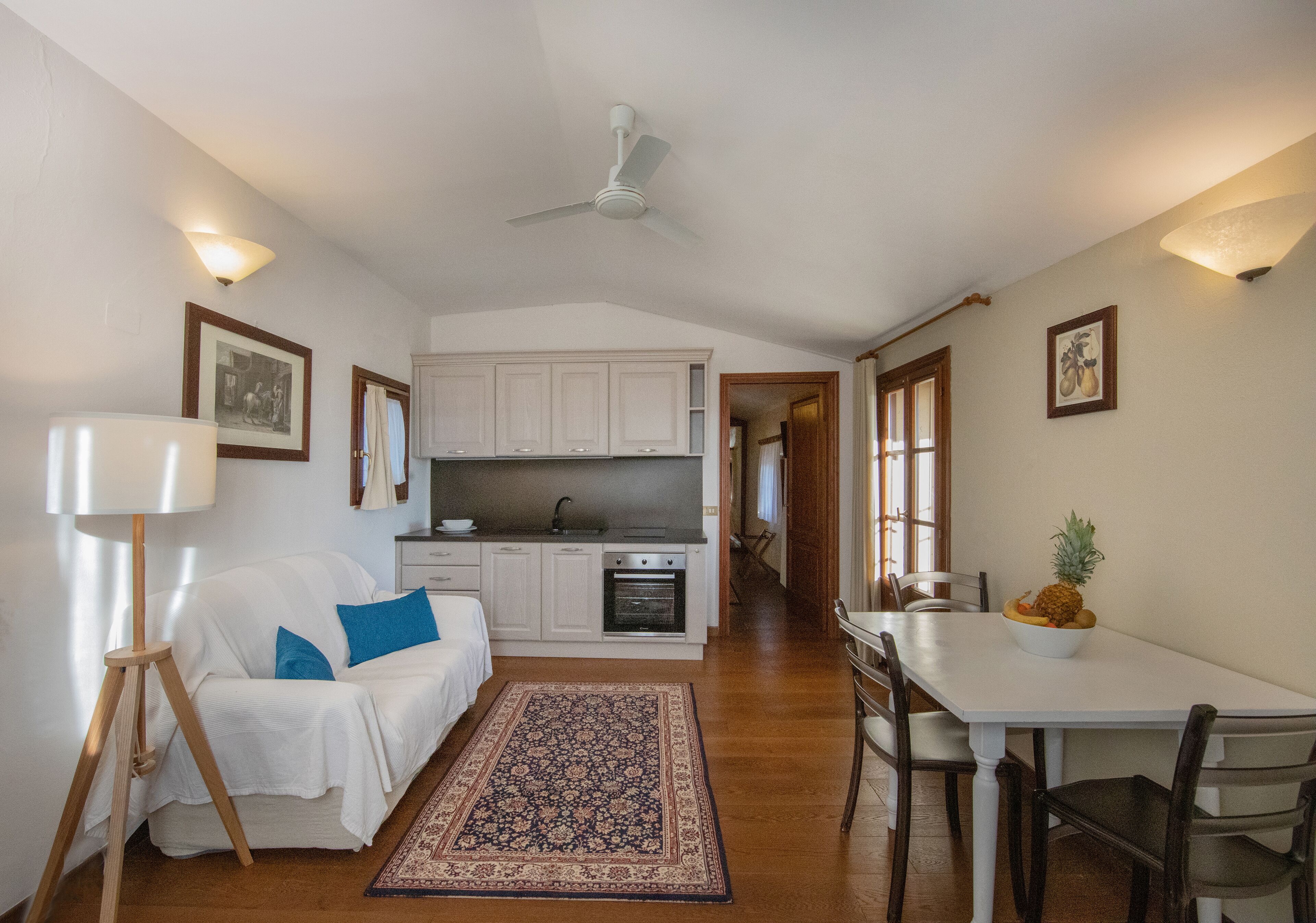 A compact living space with a kitchenette, a dining area, and a bedroom.