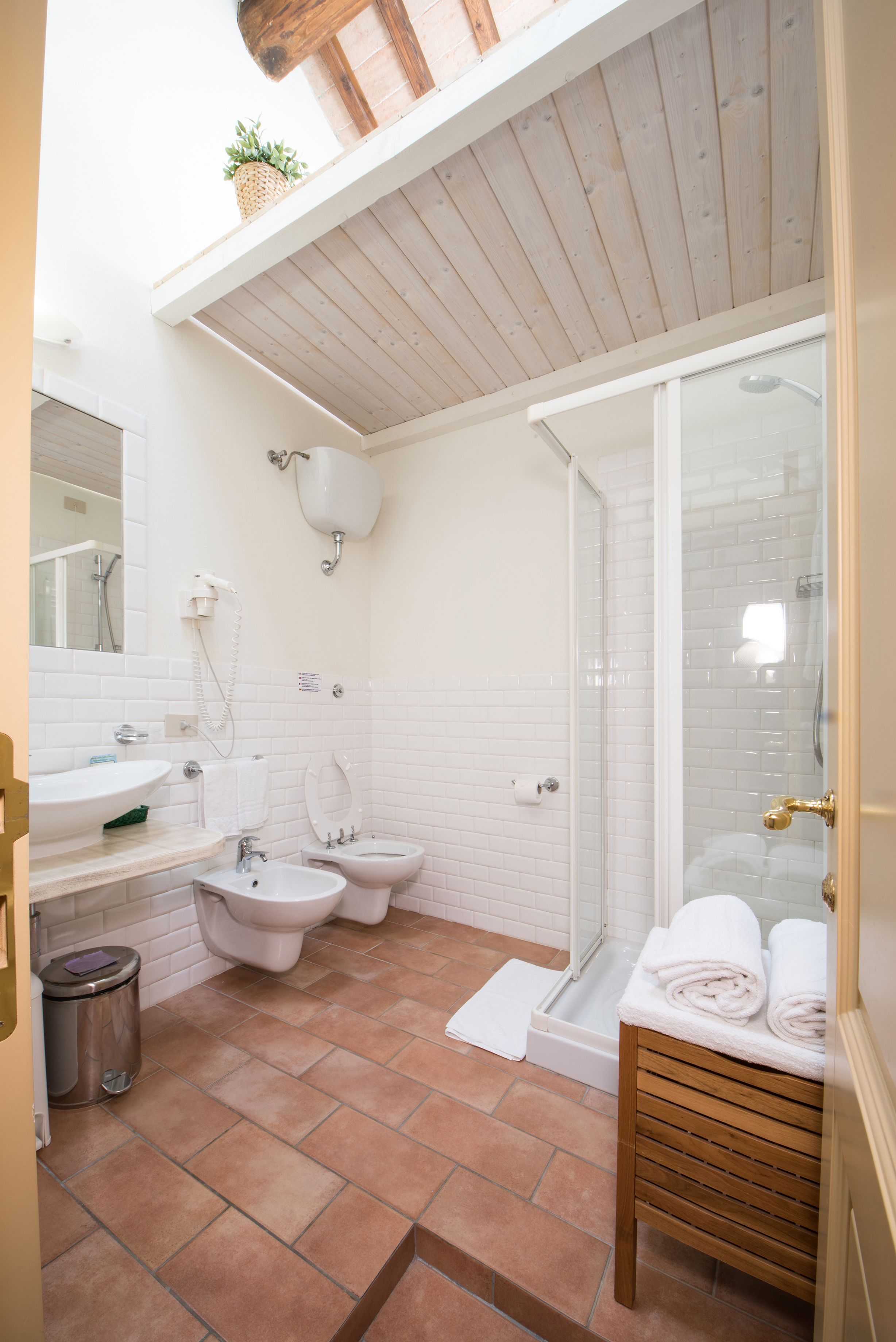 Un baño con ducha, dos lavamanos, inodoro y bidé.