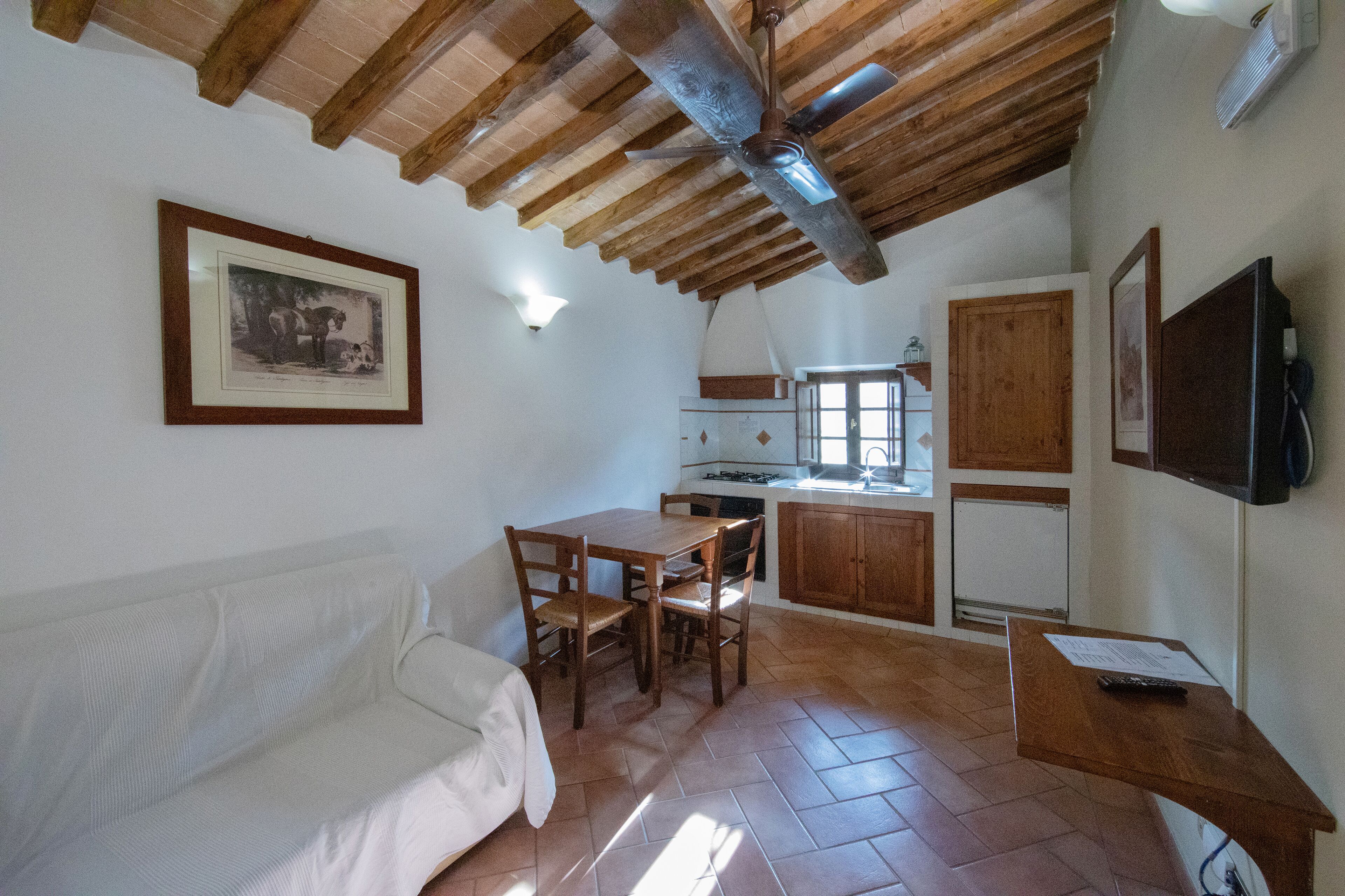 A kitchen with wooden cabinets, a dining table, and chairs.