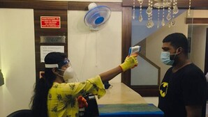 A reception area with a counter, a fan, and a sign indicating a 24-hour service. - Hotel Mumbai International (Mumbai)