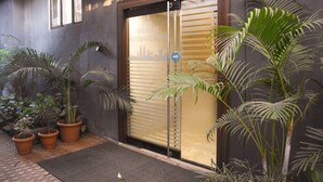 A hotel entrance with a sliding glass door, potted plants, and a 'push' sign. - Hotel Mumbai International (Mumbai)