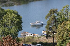 A boat on calm water surrounded by trees. - Blankaholms Bad och Naturcamping (Hjorted)