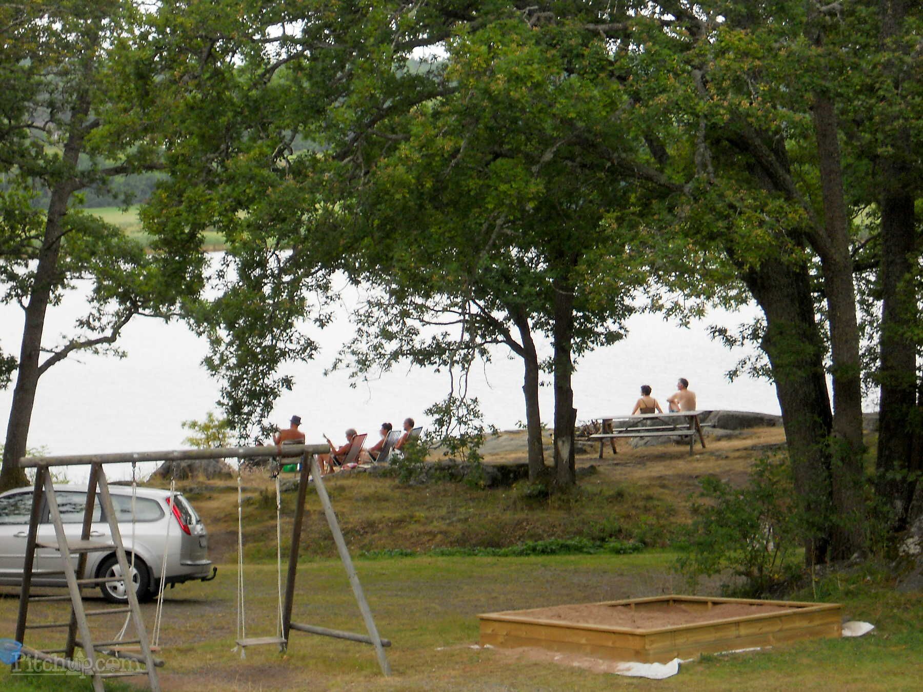 A park with picnic tables and a swing set.