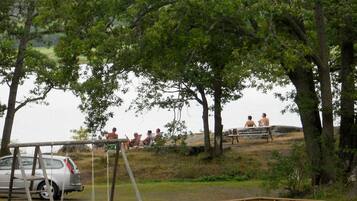 A park with picnic tables and a swing set.