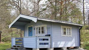 A small, single-story cabin with a porch and a set of stairs leading to the entrance. - Blankaholms Bad och Naturcamping (Hjorted)