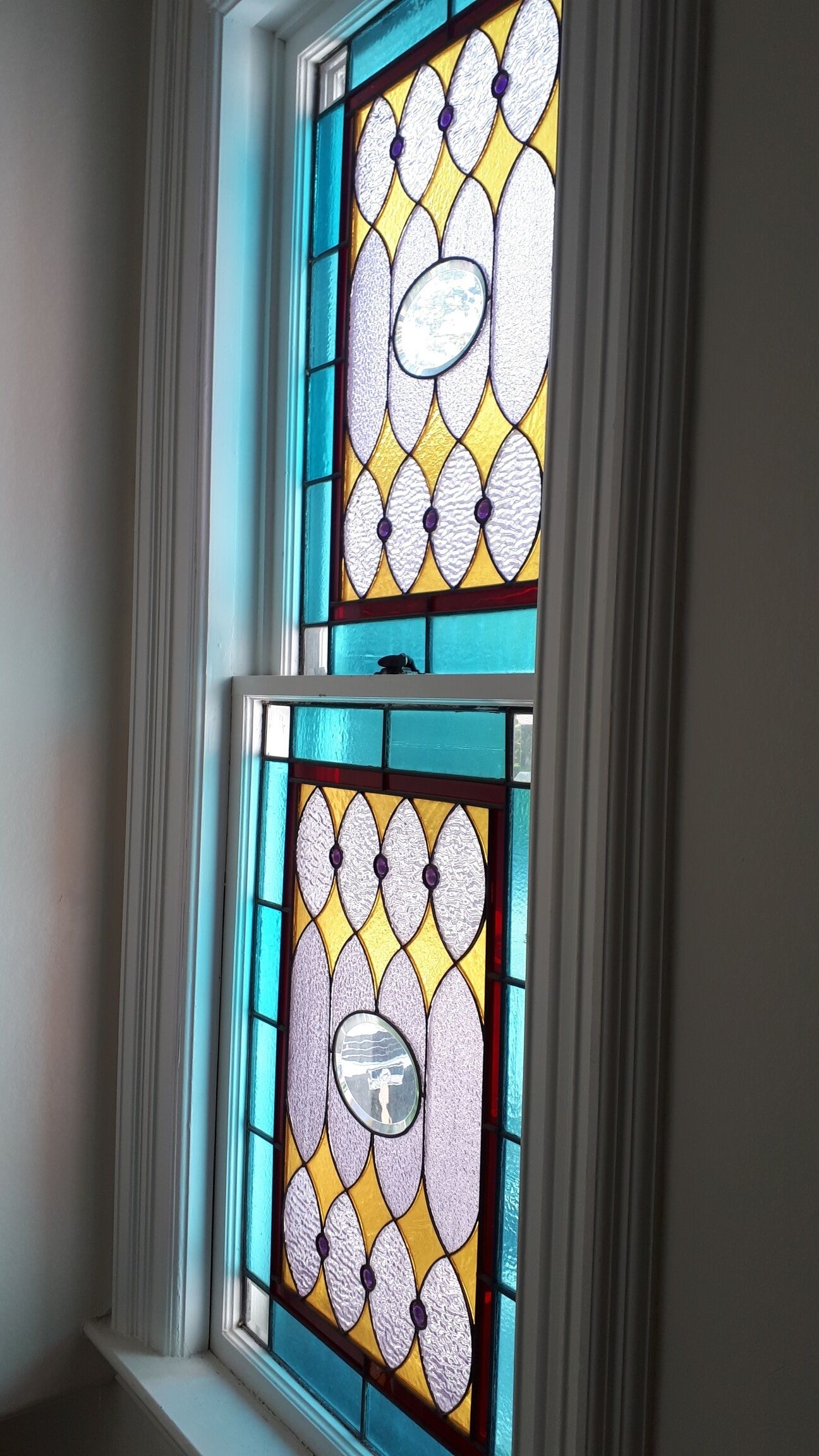 Una ventana de vitral con un diseño simétrico y un motivo circular central.