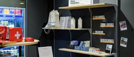 A display with various Swiss products, including a refrigerator with drinks, a table with duck figurines, and shelves with boxes and bottles.