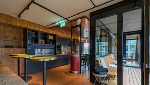 A modern bar area with a counter, stools, and a seating area with a view.