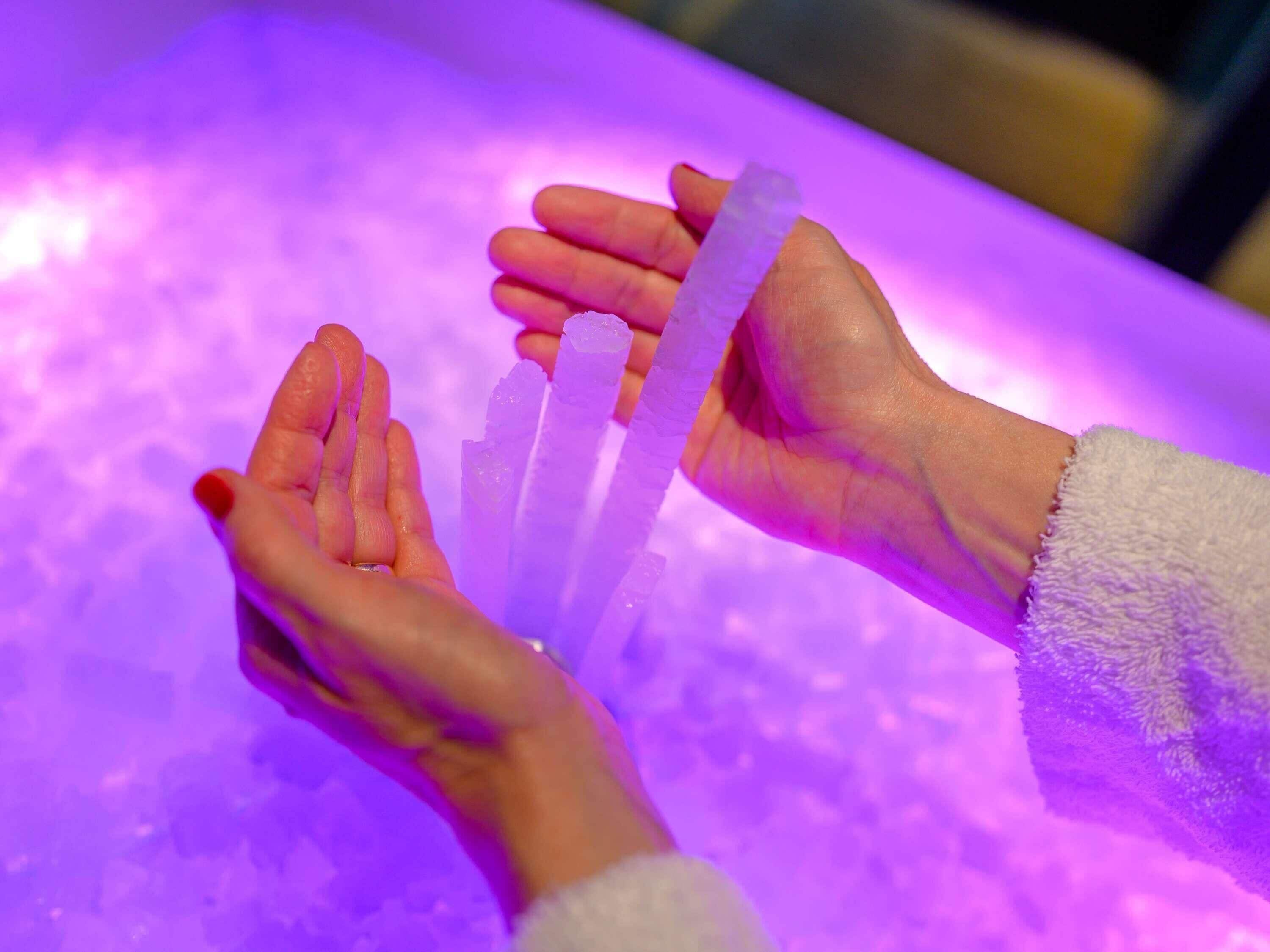 Hands holding translucent ice bars.