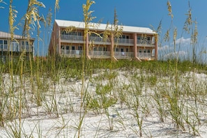 A beachfront hotel with multiple balconies and a sandy foreground. - Jen's Creole 4 Bedroom Townhouse by RedAwning (Navarre)