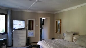 A hotel room with a bed, a desk with a computer, a television, and a mirror. - Johannesburg Youth Hostel (Randburg)