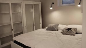 Una camera da letto con un letto, un'armadio bianco e due luci a parete.