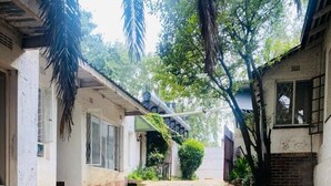 Un sendero estrecho que conduce a un edificio de fachada blanca y un pequeño jardín.