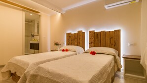 A hotel room with two beds, a wooden headboard, a small bedside table, and an air conditioning unit. - Bragora 3524 Between S. Marco & Biennale (Venice)