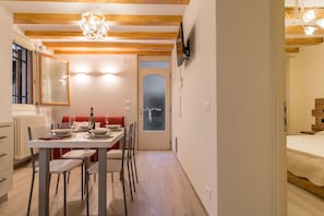 Um espaço compacto com área de refeições, cozinha compacta e quarto.