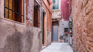 A narrow alleyway with stone walls and a tiled floor. - Bragora 3524 Between S. Marco & Biennale (Venice)