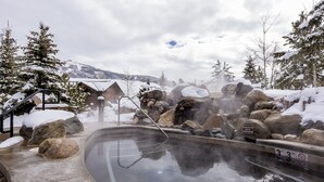 A hot spring area with a 3ft 3in depth sign, surrounded by snow-covered rocks and trees. - First Tracks 3303 2 Bedroom Condo (Steamboat Springs)
