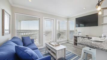Relax in this spacious living area with a comfortable sofa, coffee table, and flat-screen TV.