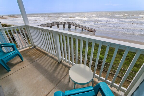 Enjoy the ocean view from this balcony with a seating area.