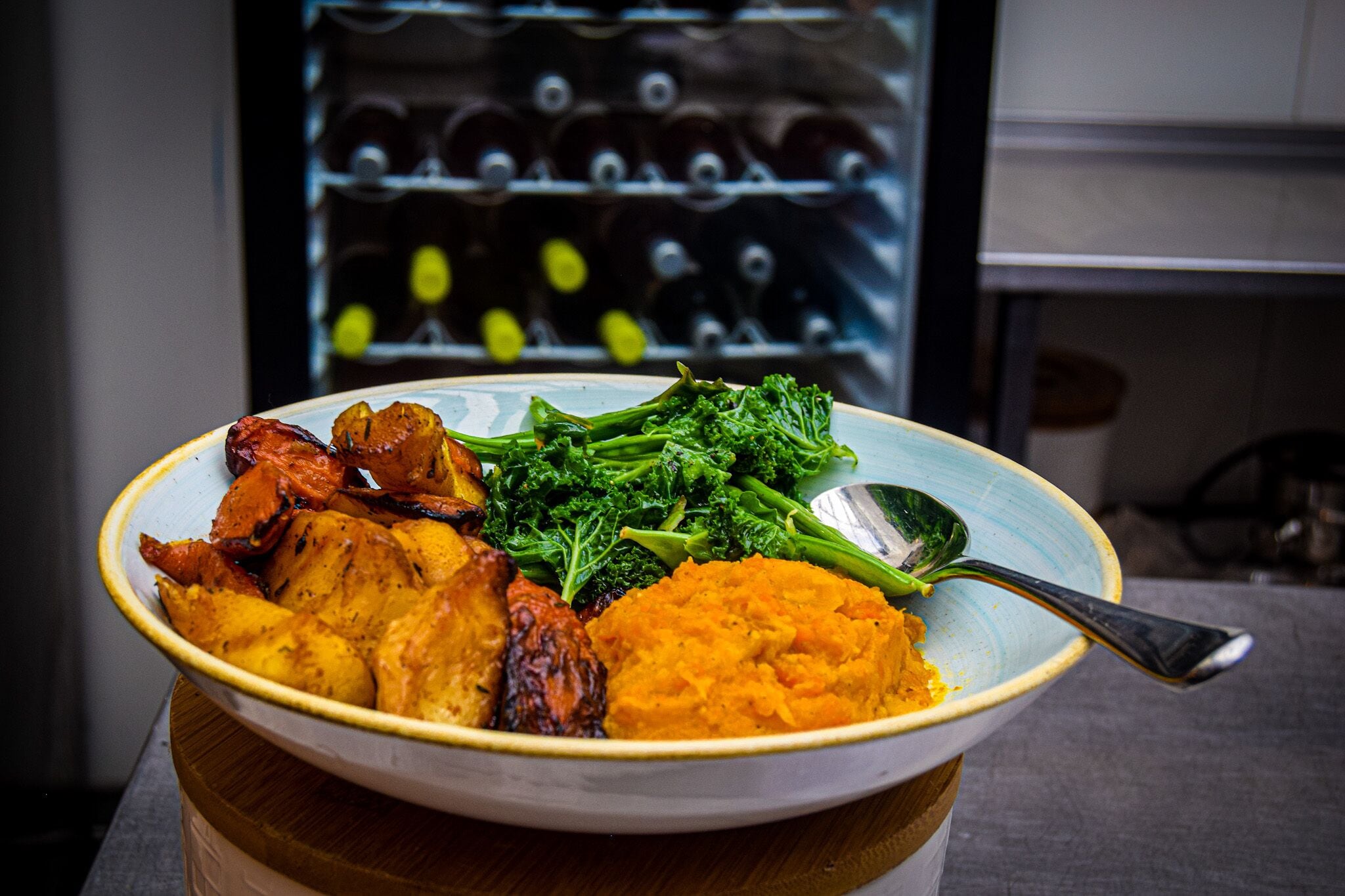 Un bol contenant de la viande rôtie, des brocolis et de la purée de pommes de terre, posé sur une table.