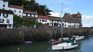 A harbor with boats, a stone wall, and buildings with thatched roofs. - Rising Sun Hotel (Lynmouth)