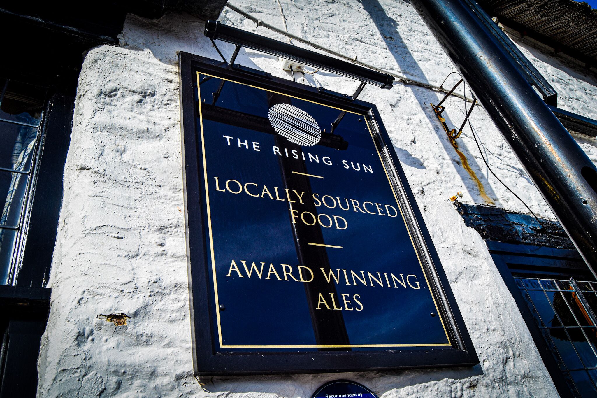 Un cartel en un edificio que dice 'The Rising Sun: cervezas premiadas con ingredientes locales y comida de la zona'.