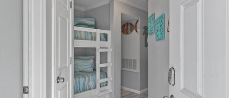 Un dormitorio con literas, una lámpara en el techo y decoración en las paredes.