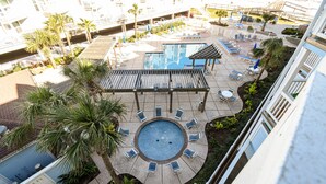 A rooftop pool area with lounge chairs and a small pavilion.