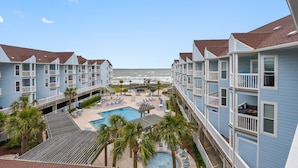 A hotel with a pool, beach view, and multiple balconies.
