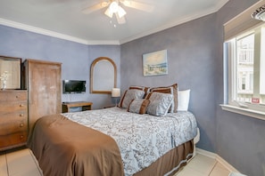 A bedroom with a bed, dresser, TV, and a window with a view. - Seascape 2105 1 Bedroom Condo by RedAwning (Galveston)