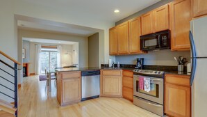 A modern kitchen with wooden cabinets, stainless steel appliances, and a central island. - Spacious B2 Townhome with Fireplace and BBQ on the Deck by RedAwning (Hood River)