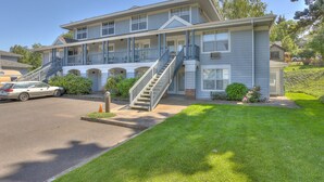 A two-story building with a front porch, a staircase, and a car parked in front. - 13 Lodge Condo Minutes Away from Golfing, Biking, and Playground by RedAwning (Hood River)