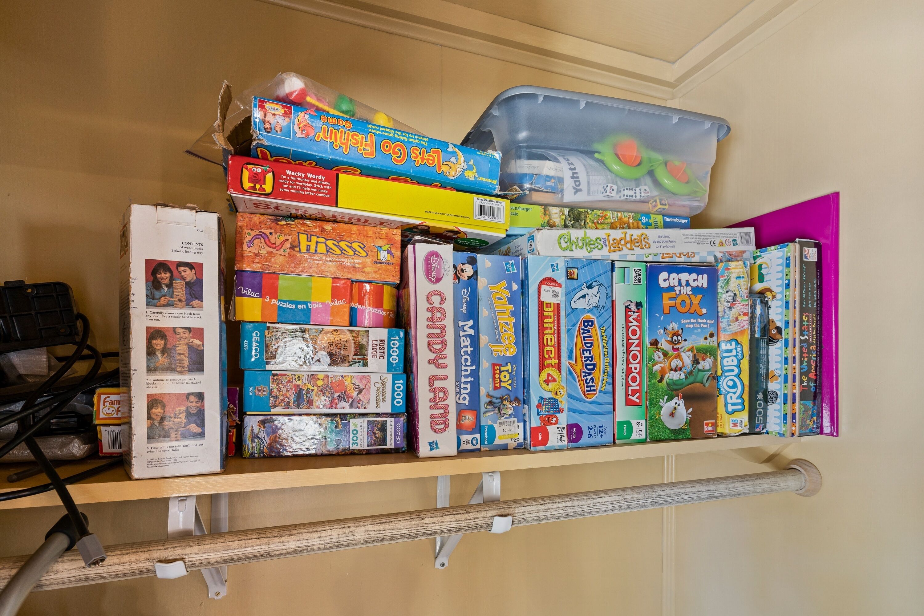 A shelf with various board games and puzzles.
