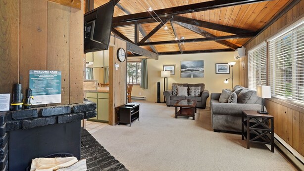 A cozy living area with a fireplace, a sofa, and a coffee table. - 7 Grizzly Home New Private Hot Tub on the Deck and Bike for Adventure by RedAwning (Bend)