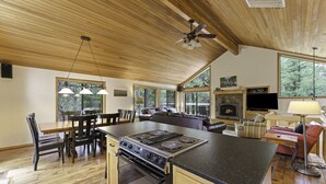 A spacious kitchen with a large island, wooden ceiling, and a fireplace. - 2 Quail Home Private Hot Tub, Steps from SHARC and short walk to the Sunriver Village by RedAwning (Bend)