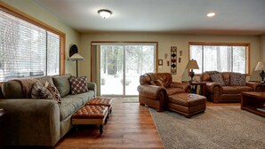 A spacious living room with a large window, a fireplace, and a cozy seating area. - Pet-Friendly 6 Otter Home features Bikes to Explore Sunriver Village by RedAwning (Bend)