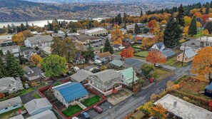 A residential area with houses, a small commercial building, and a lake in the background.