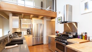 A modern kitchen with stainless steel appliances, a wooden countertop, and a built-in oven. - Mountain House 4 Bedroom Home by RedAwning (Parkdale)