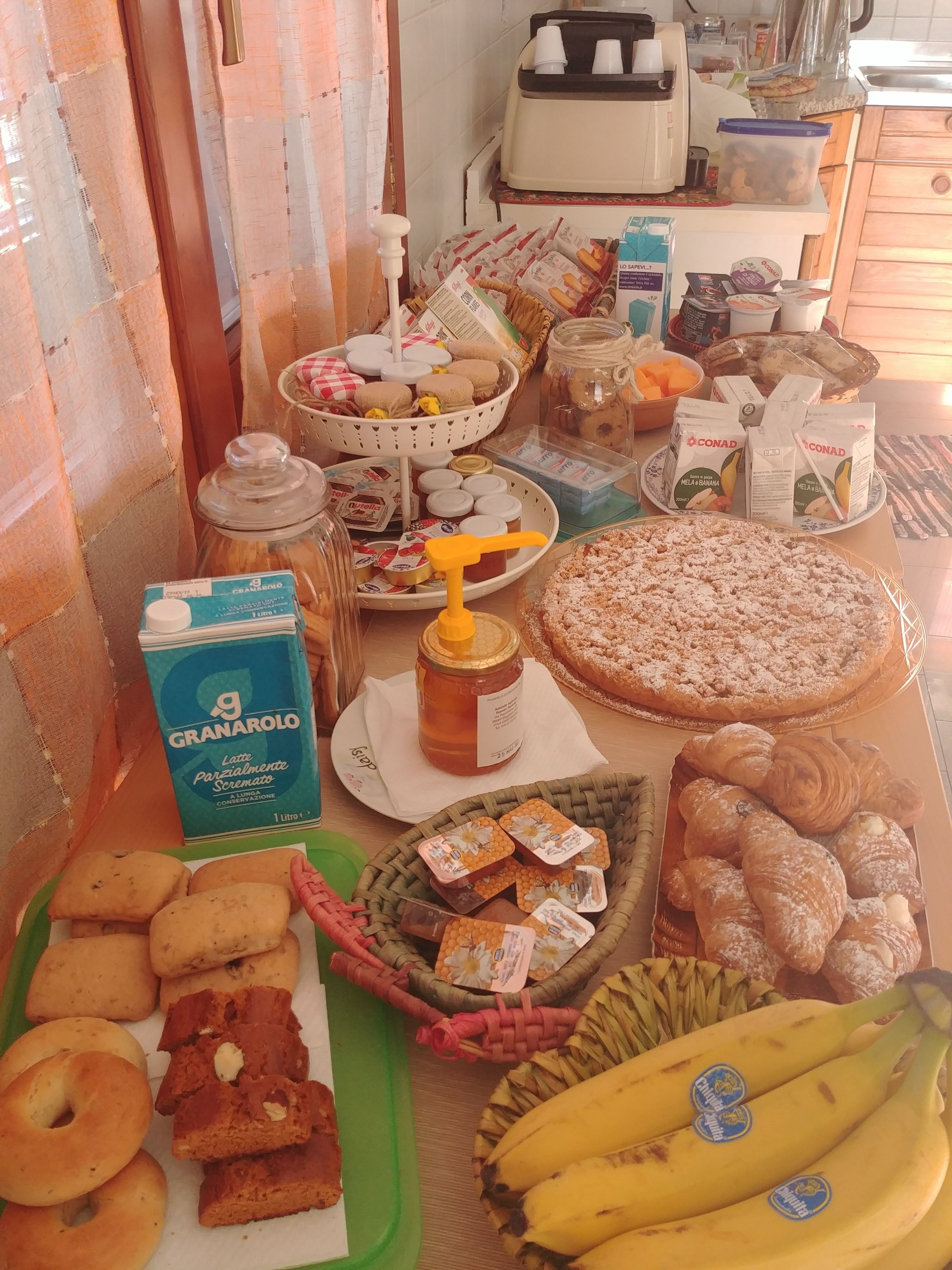 Un ricco buffet della colazione con dolci, pane e frutta fresca.